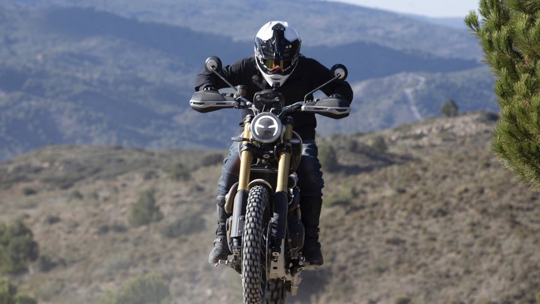 A Triumph motorbike being jumped through the air